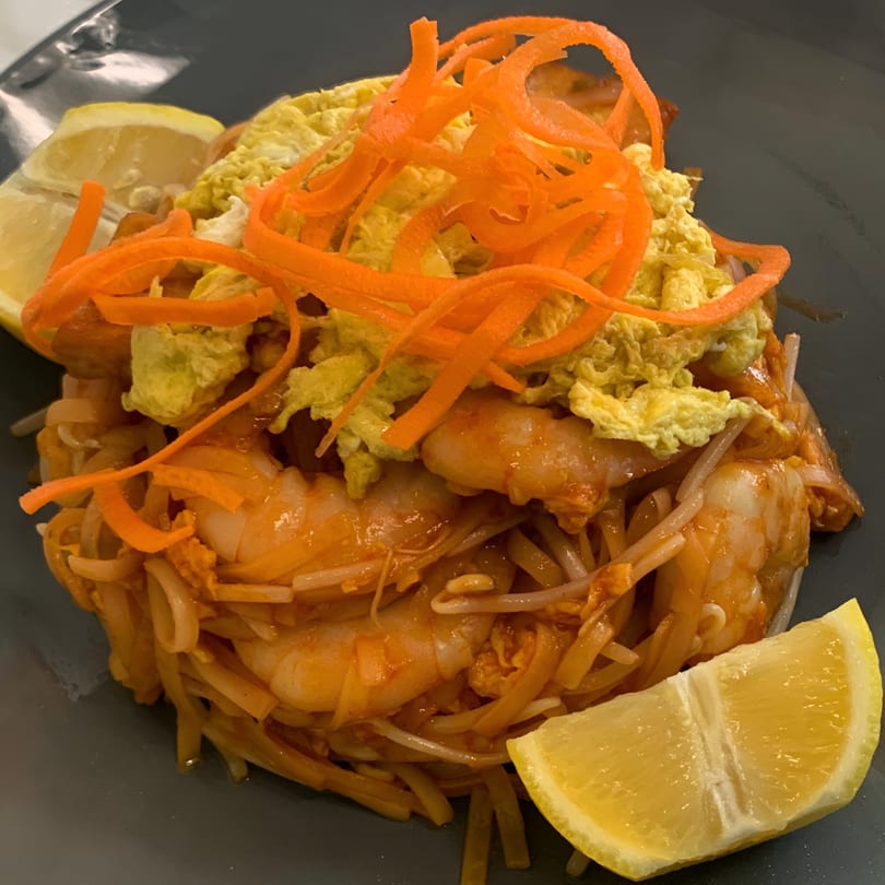 Golden Phoenix Chinese Restaurant's shrimp pad thai with shredded carrots, scrambled egg, and lemon wedges.