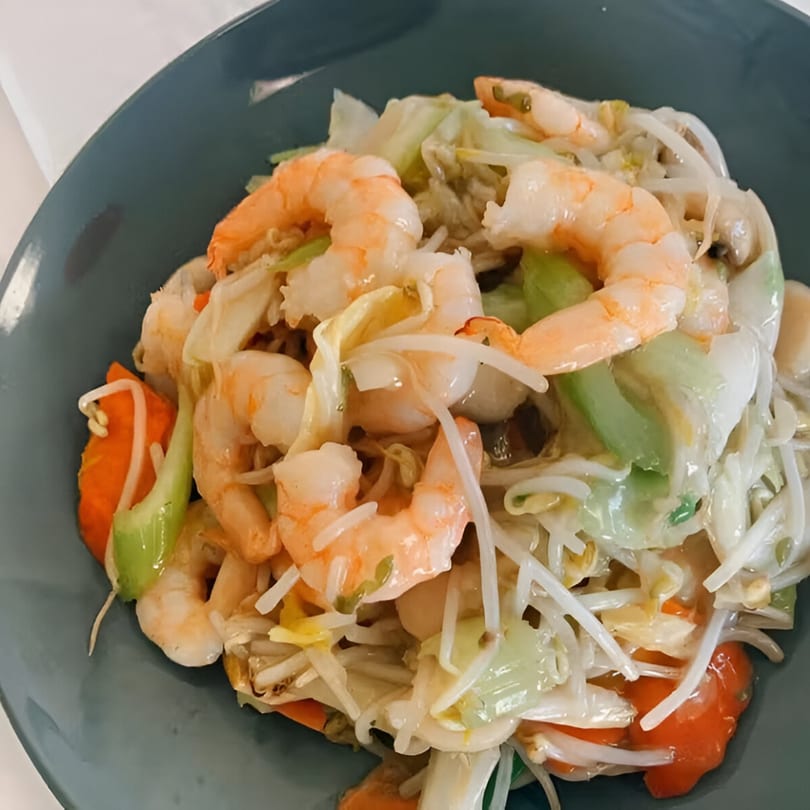 Golden Phoenix Chinese Restaurant's shrimp chow mein with vegetables and bean sprouts in a blue bowl.